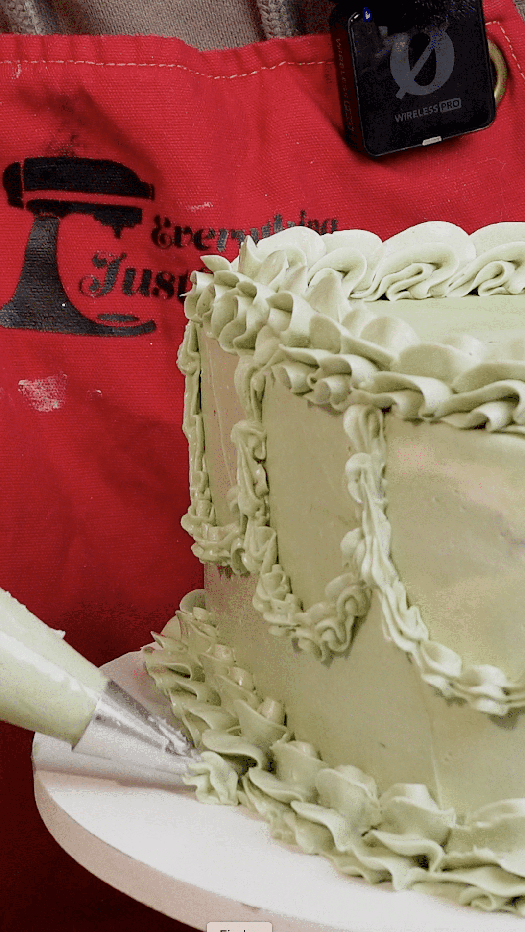 Baker adding final buttercream piping details using a star tip for texture.